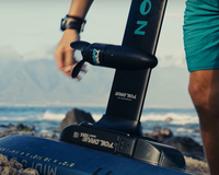 Green Hat Kiteboarding-Foil Drive Max on North Midi Foilboard-Live Shot-Board and Foil on Rocky Beach in Front of Mountains