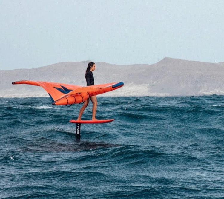 Green Hat Kiteboarding-Collection Clearance Wings-Woman Free Flying an F-One Strike on a Downwinder