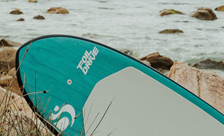 Green Hat Kiteboarding-Sunova Foil Drive Foilboard on a Rocky Beach