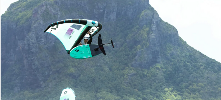 Green Hat Kiteboarding-Wingfoiling-Wing Safety Gear-Ion Vector Vest AMP Front Zip & Ion Helmet on Winger in the air Riding Duotone Unit Wing and Fanatic Board
