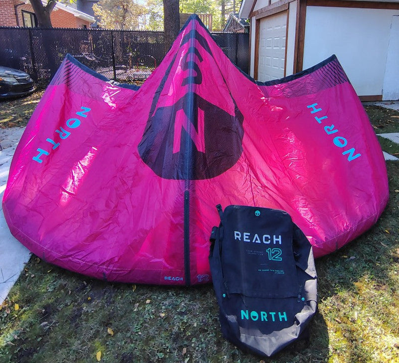 Load image into Gallery viewer, Green Hat Kiteboarding-2024 12m North Reach Kite-Pink kite with 'North' branding on a grassy area with Bag