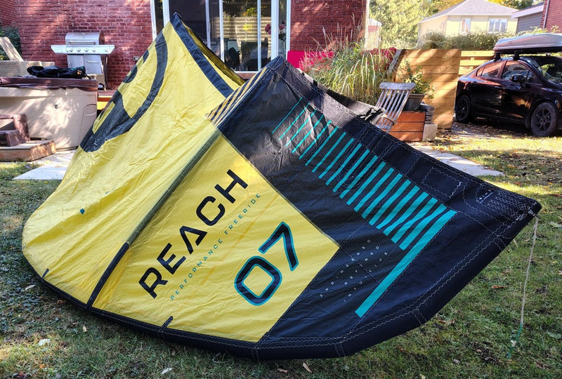 Load image into Gallery viewer, Green Hat Kiteboarding-2024 7m North Reach Kite-Right Wing Tip View of Sunset Yellow kite with 'North' branding on a grassy area