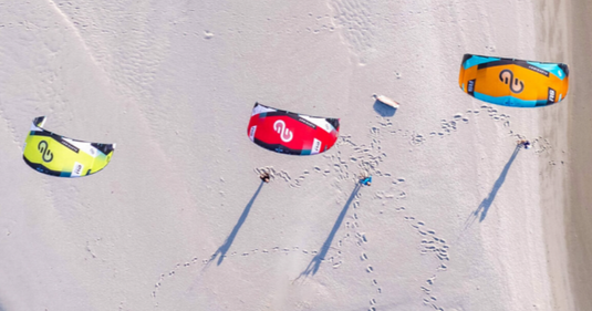 Green Hat Kiteboarding- Eleveight RS V9-Live Shot-Three Eleveight RS in the Air on a Beach