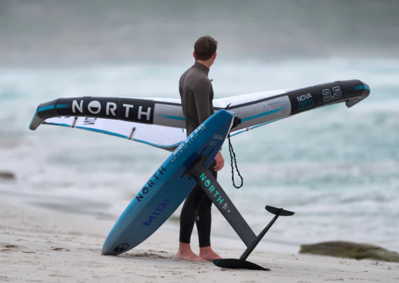 Load image into Gallery viewer, Green Hat Kiteboarding-2025 North Midi Mid-Length Foilboard-Board on Beach next to Wing Foiler