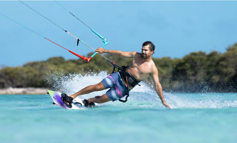 Load image into Gallery viewer, Green Hat Kiteboarding-2026 Duotone Select SLS Twintip-Action Shot-Man Kiteboarding Toeside on a Select SLS kiteboard