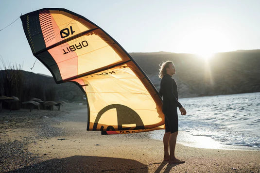 Load image into Gallery viewer, Green Hat Kiteboarding-2026 North Orbit Kite-Action Shot-Man Holding the North Orbit on the Beach