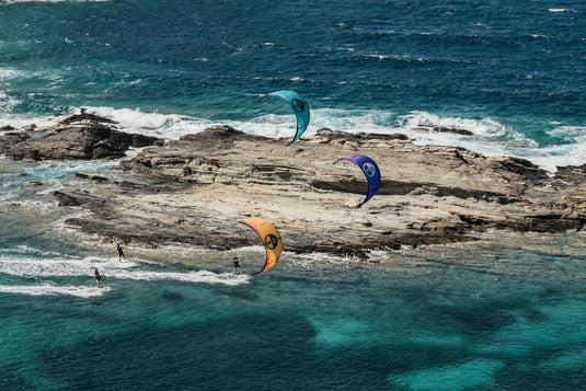 Load image into Gallery viewer, Green Hat Kiteboarding-2026 North Orbit Kite-Action Shot-3 Kites Flying in Front of a Large Boulder