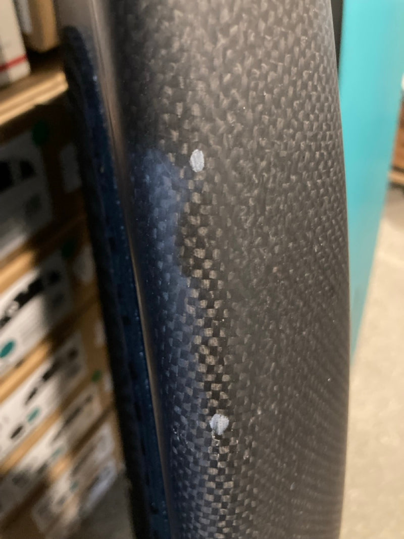 Load image into Gallery viewer, Green Hat Kiteboarding-4'6 Ozone Pulse V1 Carbon Foilboard USED-Close Up View of Edge Scratches on a Wooden Background