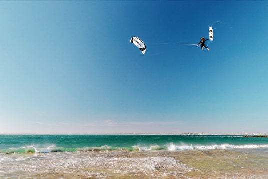 A person kiteboarding with a Core XR7 7m Kite USED, soaring through the sky above the ocean.