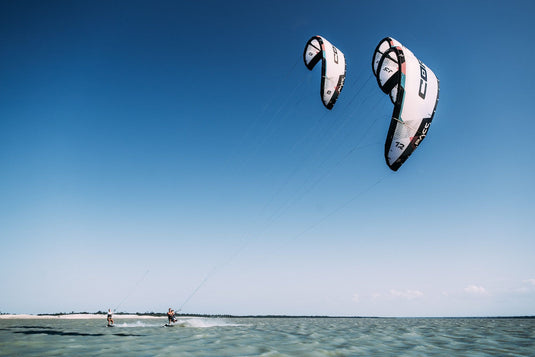 Green Hat Kiteboarding-Core Pace White Color-Action Shot- 3 Kites Flying Over the Water