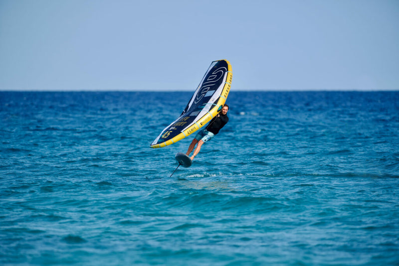 Load image into Gallery viewer, Green Hat Kiteboarding-Eleveight WFS Pro V2 Wing-Action Shot-Man Wing Foiling on a WFS V2 on Ocean Blue Water
