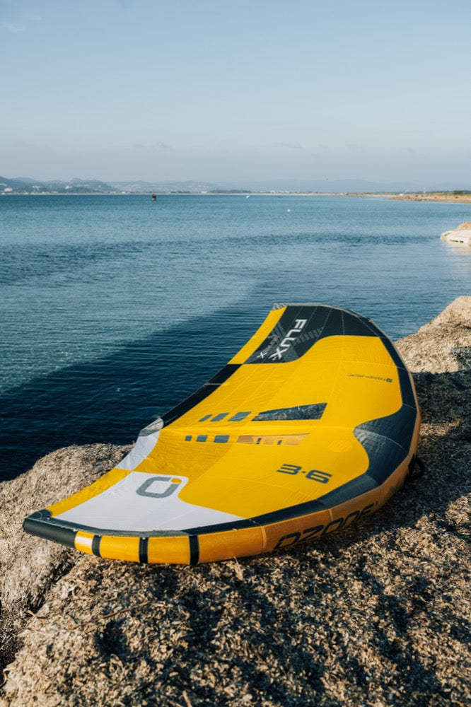 Load image into Gallery viewer, Green Hat Kiteboarding-Ozone Flux V2 Ultra X Wing-Yellow-Live Shot-Flux Wing on Rocks Near Water