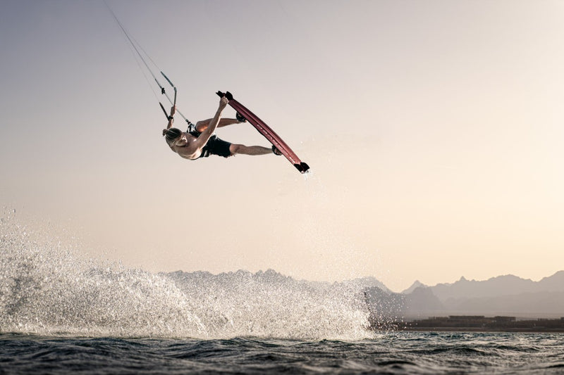 Load image into Gallery viewer, Green Hat Kiteboarding-Carved Imperator PRO-Action Shot-Man Jumping While Kiteboarding Riding a Carved Imperator PRO