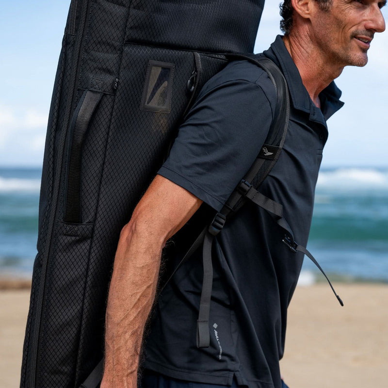 Load image into Gallery viewer, Green Hat Kiteboarding-2025 Lift5 Board Bag-Action Shot-Man Carrying Lift5 eFoil in Black Backpack