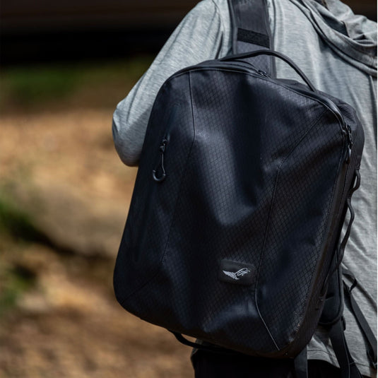 Green Hat Kiteboarding-2025 Lift5 Board Bag-Action Shot-Man Carrying Lift5 eFoil Battery in Black Backpack