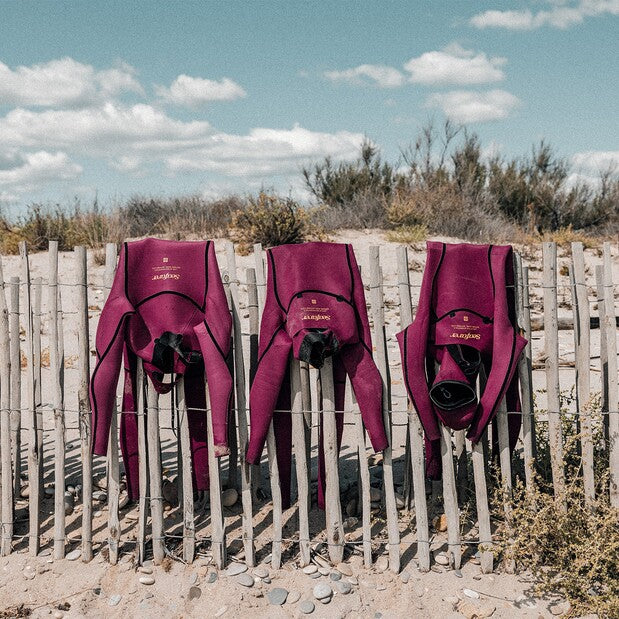 Load image into Gallery viewer, Green Hat Kiteboarding-Manera Seafarer 4/3 FZip Wetsuit-Live Shot-Three Manera Seafarers inside Out Drying on a Wooden Fence
