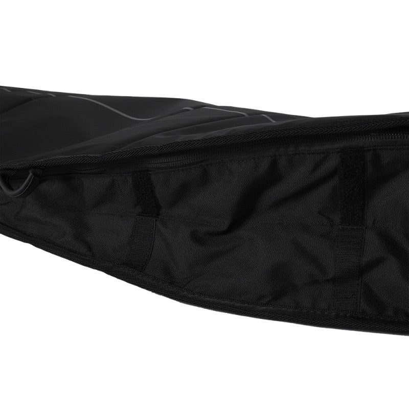 Load image into Gallery viewer, Close-up of a black quilted jacket with a brand logo on a white background