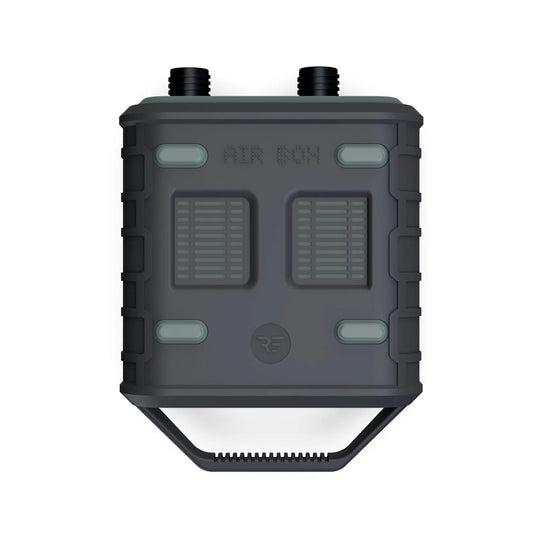 A black square object with two buttons, two vents, and a grey rectangular object with white lines - Ride Engine Air Box Electric Pump.