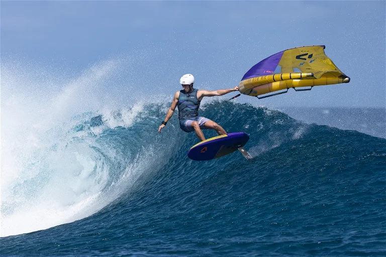 Load image into Gallery viewer, 2024 Duotone Unit D/LAB Foil Wing Clay/Violet-Winger wearing white helmet surfing a wave