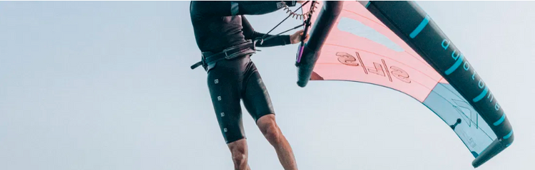 Green Hat Kiteboarding-Ion Wing Foil Harness hooked onto a Duotone Unit Wing for Wing Foiling