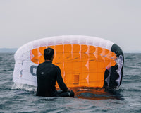 Green Hat Kiteboarding-BLOG-Man Sitting on a Board Flying an Ozone Pocket Rocket