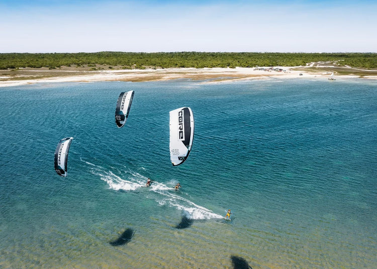 Green Hat Kiteboarding-Kiteboarding Collection-3 black and white Core kites on blue flat water.