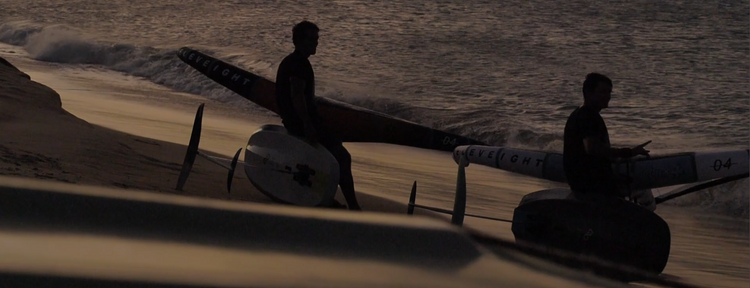 Green Hat Kiteboarding-Collection-Foil Accessories-Misc.-Two Men Sitting on Their Wing Boards on the Beach in the light of Dusk