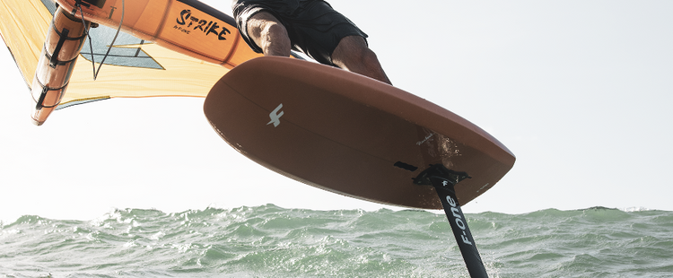 Green Hat Kiteboarding-Clearance Wing Foil Board Collection-F-One Rocket Board-View of the Bottom of the board and the foil of a man winging