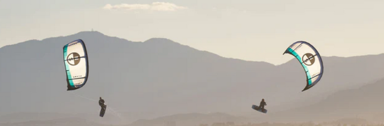 Green Hat Kiteboarding-All Kites collection-two kiters in the air on white North Kites-Mountain Backdrop-North Orbit-North Action Sports