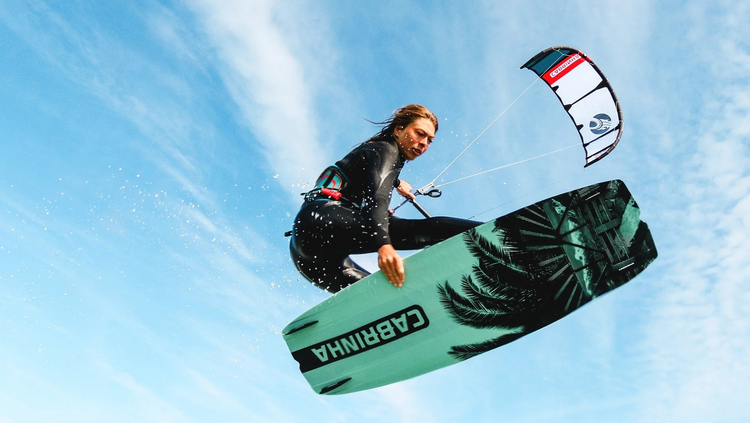 Green Hat Kiteboarding-Kiteboarding Packages Collection-Hannah Whitley in the air on her Cabrinha kite and Board