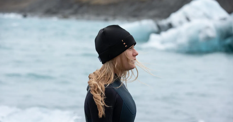 Green Hat Kiteboarding-Waterwear-All Extremities-Ion TEC Water Beanie-Worn by a Blond Woman in front of an Iceberg