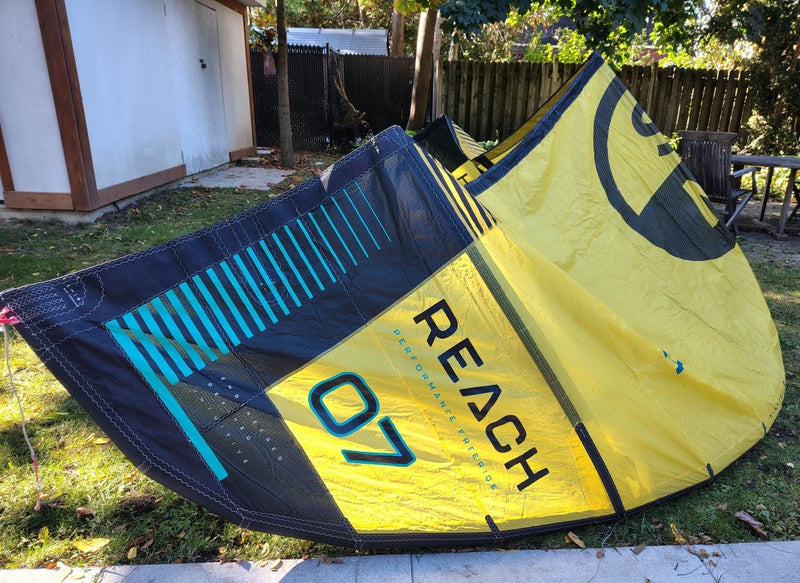 Load image into Gallery viewer, Green Hat Kiteboarding-2024 7m North Reach Kite-Left Wing Tip View of Sunset Yellow kite with &#39;North&#39; branding on a grassy area 
