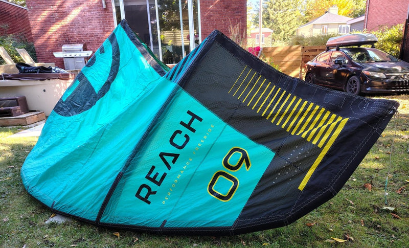 Load image into Gallery viewer, Green Hat Kiteboarding-2024 9m North Reach Kite-Right Wing Tip View of Turquoise kite with &#39;North&#39; branding on a grassy area 
