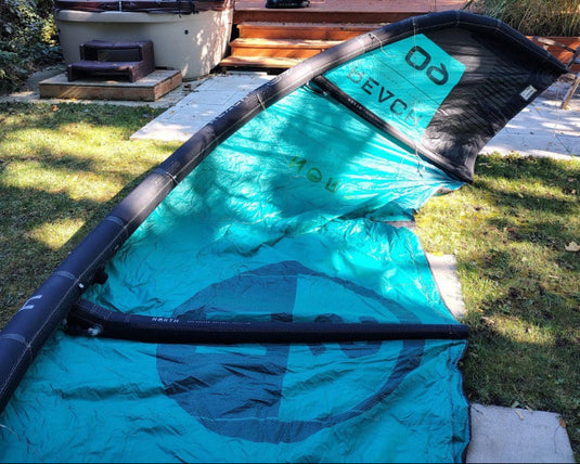 Green Hat Kiteboarding-2024 9m North Reach Kite-Inside Right Wing Tip View of Turquoise kite with 'North' branding on a grassy area