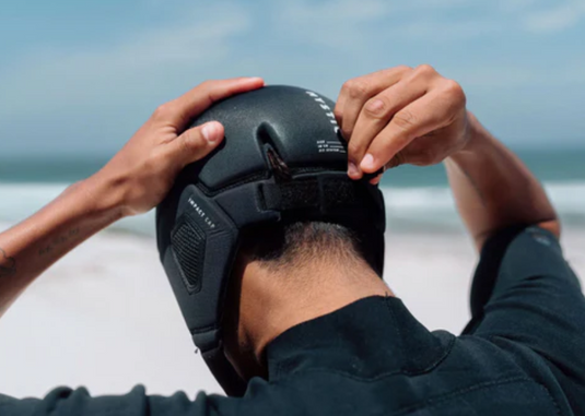 Green Hat Kiteboarding-2024 Mystic Impact Cap-Black-Live Shot-Man Adjusting his Black Mystic Impact Helmet