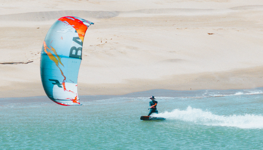 Green Hat Kiteboarding-2025 F-One Bandit Limited Edition by Brianchild Kite-Live Shot-Man Riding the Bandit by Brainchild on Crystal Blue Waters