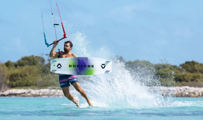 Load image into Gallery viewer, Green Hat Kiteboarding-2026 Duotone Select SLS Twintip-Action Shot-Man Kiteboarding on a Select SLS kiteboard doing a Jesus Walk
