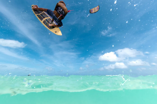 Green Hat Kiteboarding-2026 Duotone Traction Pad SLS Front-Action Shot-Man in the Air Kitesurfing