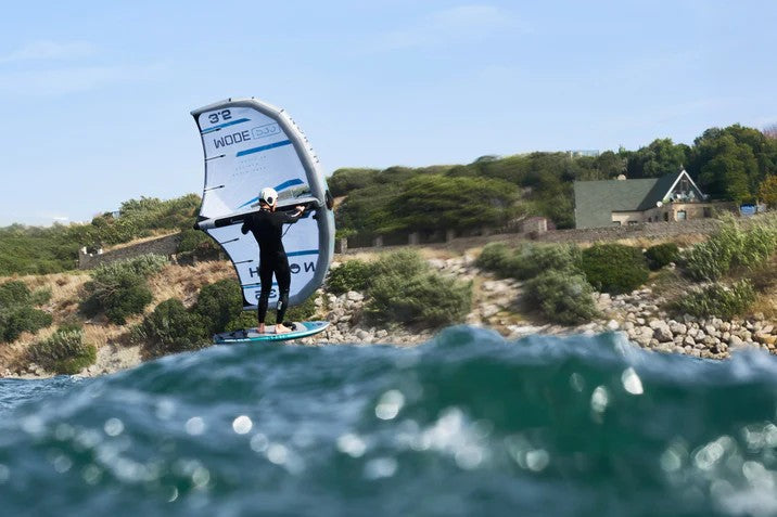 Load image into Gallery viewer, Green Hat Kiteboarding-2026 North Mode Pro Wing-Action Shot-Man Wing Foiling in Front of House on a Cliff
