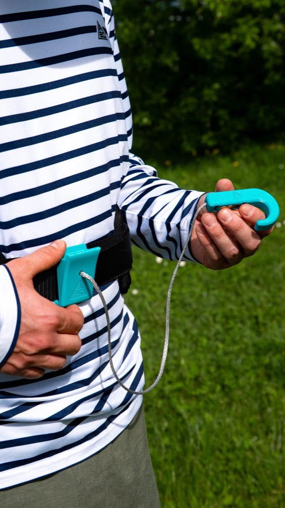 Load image into Gallery viewer, Person holding a turquoise A3D Magnetic Hook with a cord, standing on grass
