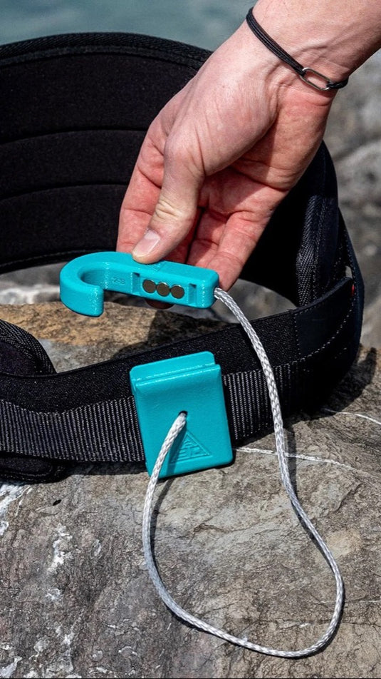 Person holding a A3D Magnetic Hook blue clip on a stone surface