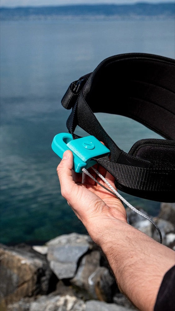 Load image into Gallery viewer, Person holding a A3D Magnetic Hook attached to a black belt against a water background
