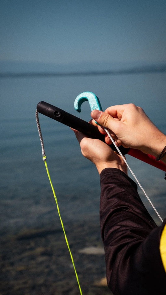 Person holding a bar with a A3D Magnetic Hook on a blurred background of water and sky