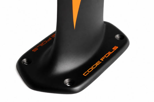 Close-up of a black Code Foils mast top plate with orange branding and a small orange chevron, shown on a white background.
