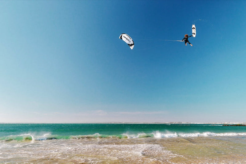 Load image into Gallery viewer, A person kiteboarding with a Core XR7 7m Kite USED, soaring through the sky above the ocean.
