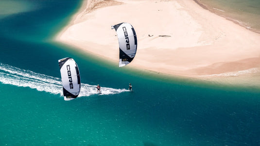 The Core XR7 7m Kiteboarding Kite, soaring through the air with people kitesurfing on the water.