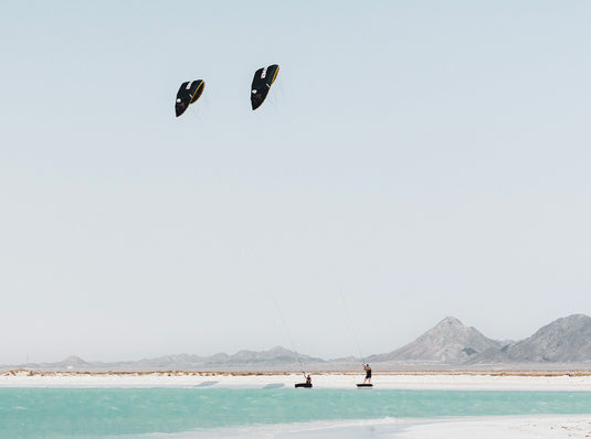 Green Hat Kiteboarding-Core XR Pro 2 Kite-Action Shot-Man and Woman on a Beach Flying the XR2 Pro