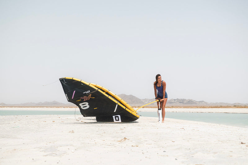 Load image into Gallery viewer, Green Hat Kiteboarding-Core XR Pro 2 Kite-Live Shot-Woman Pu the XR2 Pumping the XR Pro 2 on the Beach
