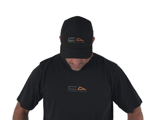 Green Hat Kiteboarding-Code Foils Cap-Man Looking Down Wearing Code Cap on a White Background