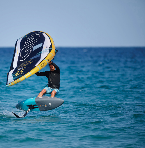 Load image into Gallery viewer, Green Hat Kiteboarding-Eleveight WFS Pro V2 Wing-Action Shot-Man Wing Foiling on a 4.5m WFS V2 on Ocean Blue Water
